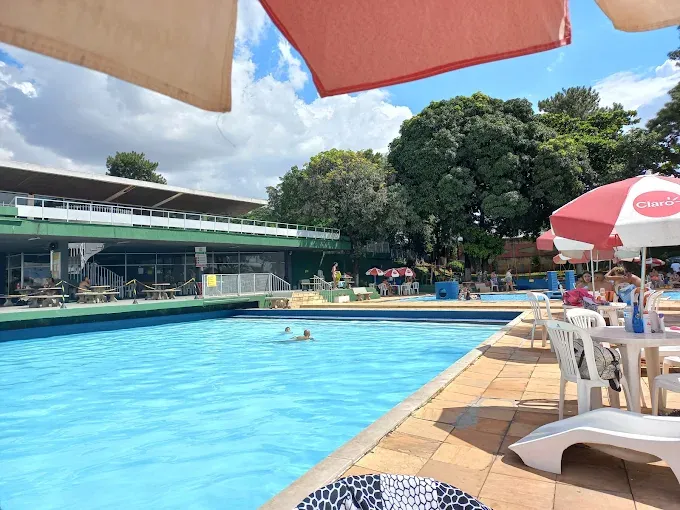 Piscina com guarda-sóis e área de convivência